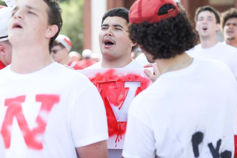 a group of people wearing white t-shirts with red letters