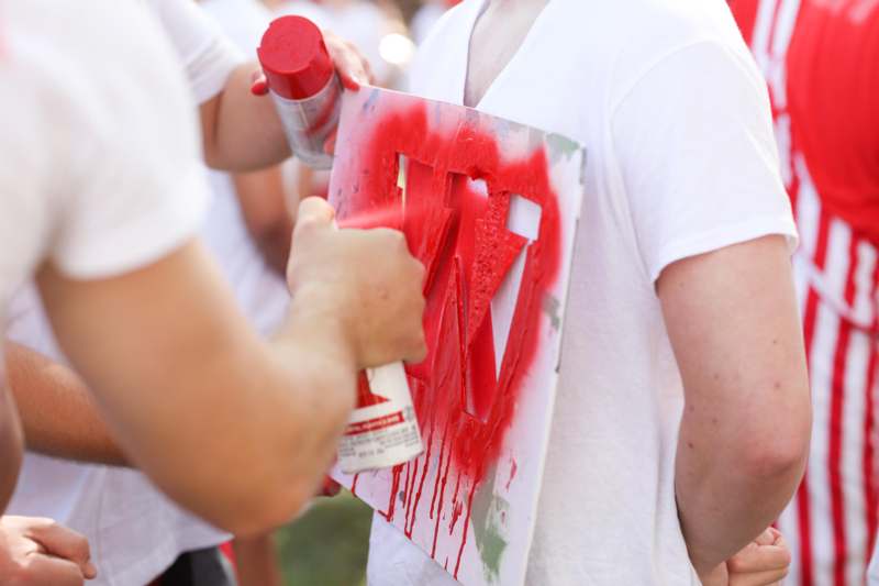 a person spraying red paint on a sign