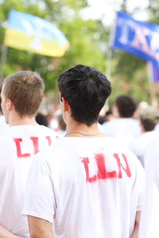 a group of people wearing white t-shirts with red text on them