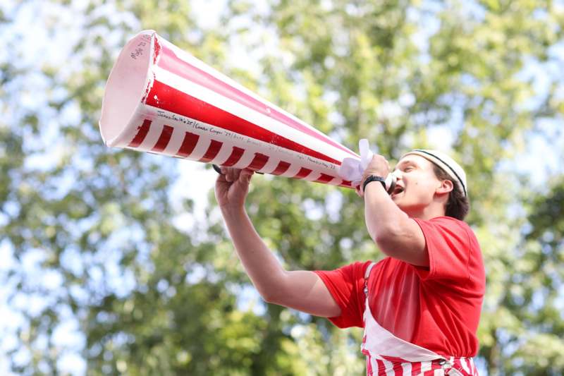 a man in a red and white striped outfit speaking into a megaphone
