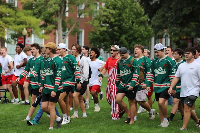 a group of people in green uniforms walking on grass