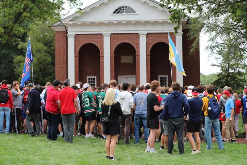 a group of people standing in a line outside a building