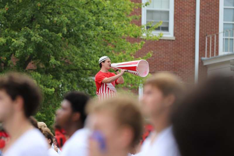 a man in a red and white striped shirt speaking into a megaphone