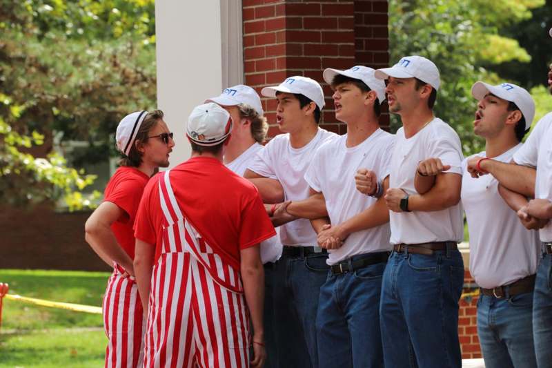a group of men wearing white caps and white shirts