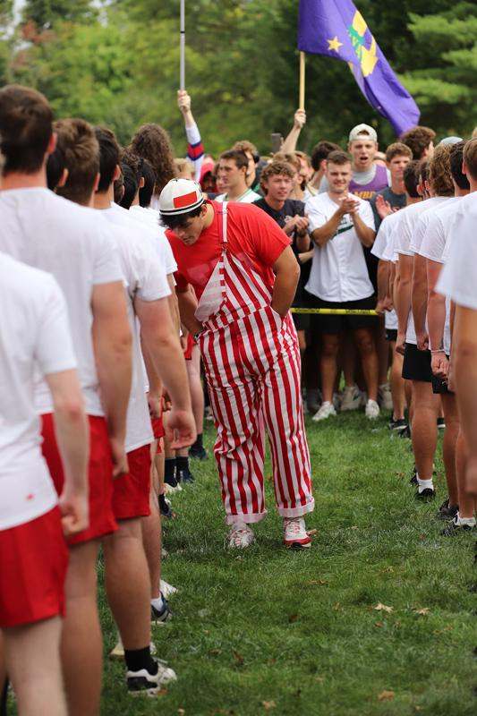 a man in a striped red and white outfit standing in a crowd