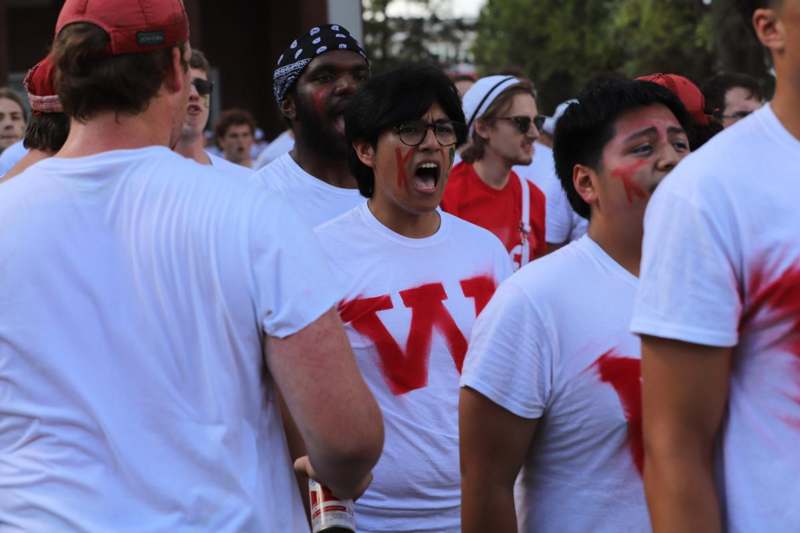 a group of people wearing white shirts with red letters on them