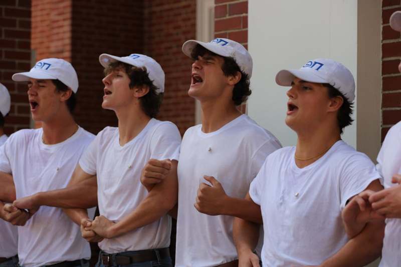 a group of men wearing white shirts and white hats