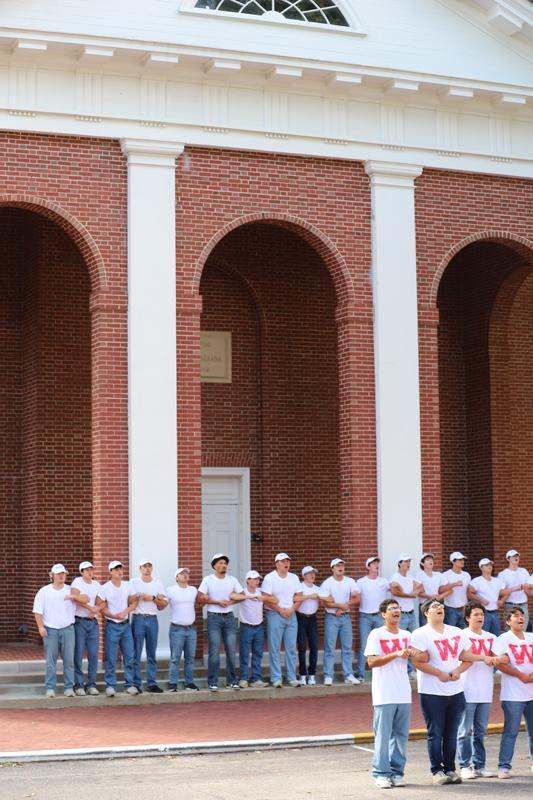 a group of people standing in front of a brick building