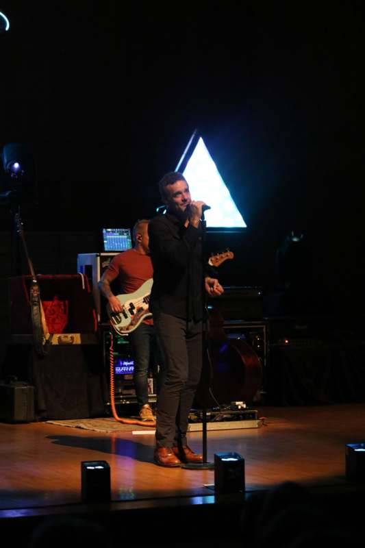 a man singing into a microphone on a stage
