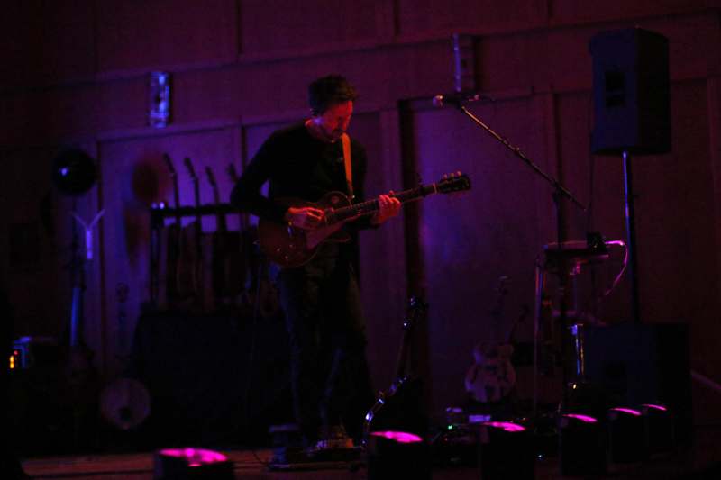 a man playing guitar on a stage