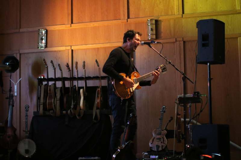 a man playing guitar on a stage