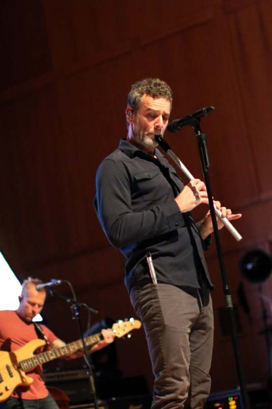 a man playing a flute on a stage