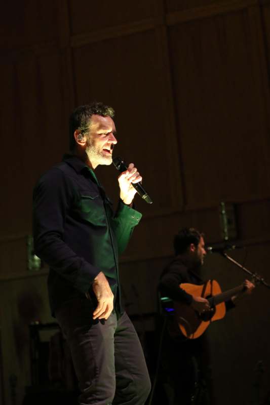a man holding a microphone and singing into a microphone