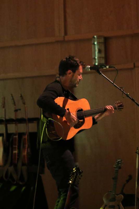 a man playing guitar on a stage