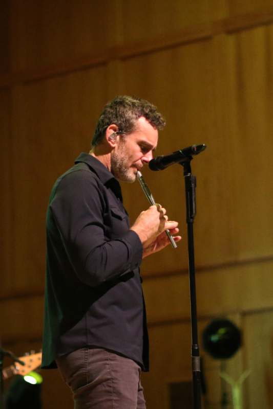 a man playing a flute on a stage