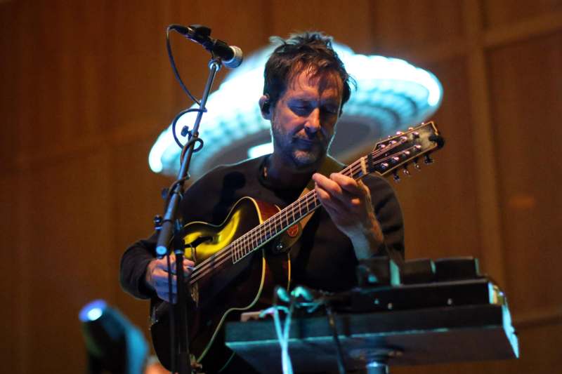 a man playing guitar on a stage