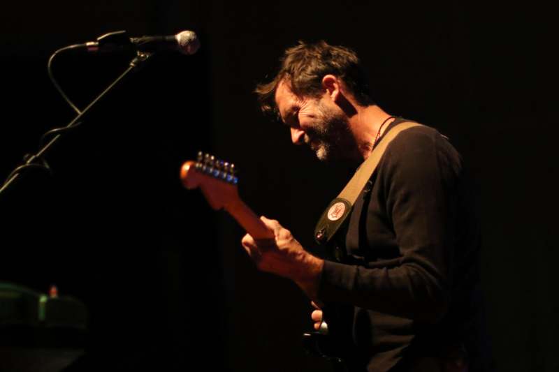 a man playing guitar in front of a microphone