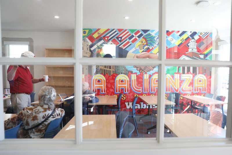 a group of people sitting at tables in a room with a window