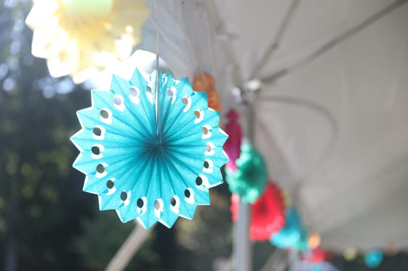 a blue paper flower from a white tent