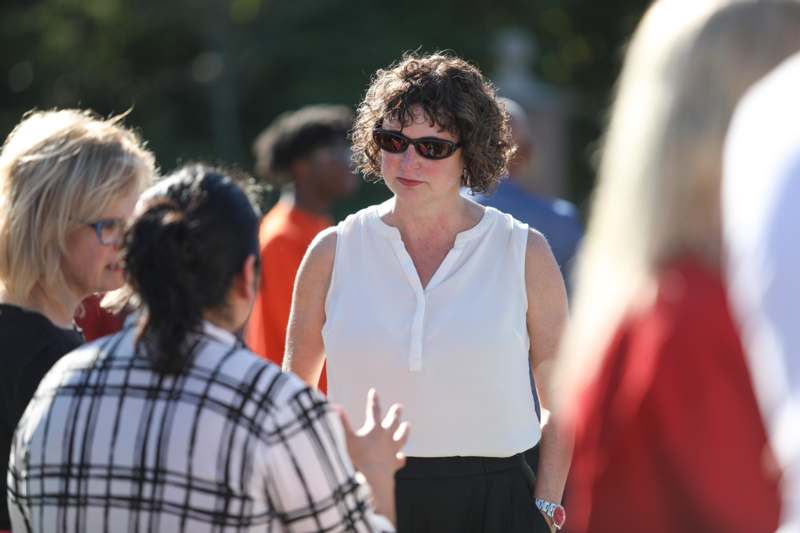 a woman in sunglasses standing in a crowd