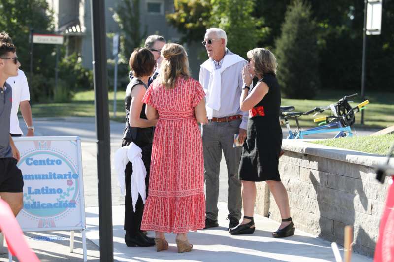 a group of people standing on a sidewalk