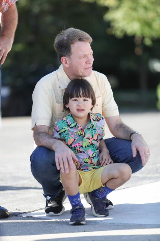 a man squatting with a child on his lap