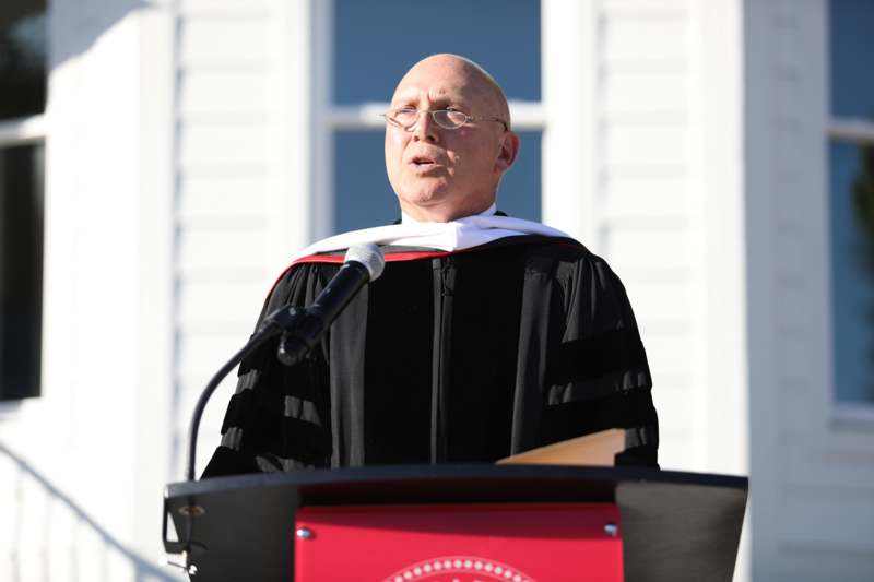 a man wearing a robe and standing at a podium