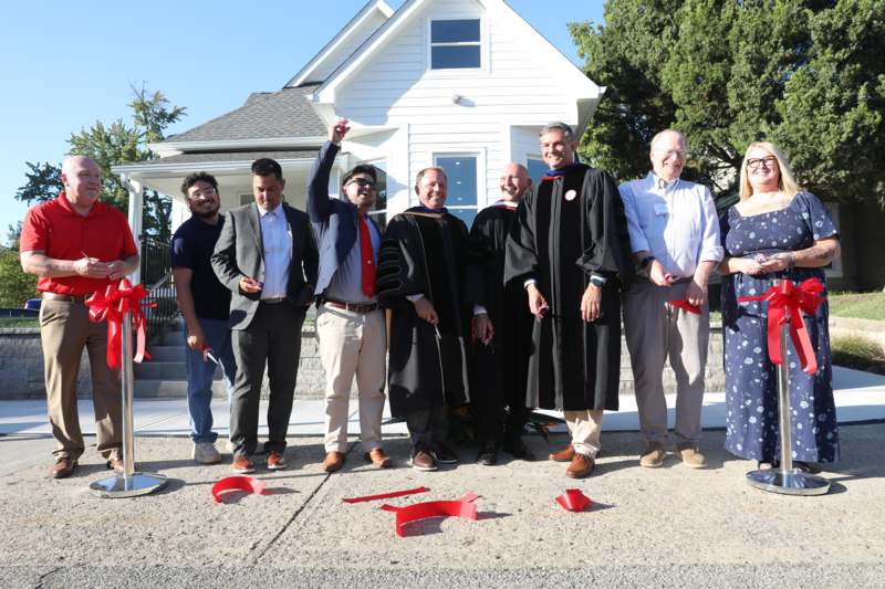 a group of men standing in front of a house