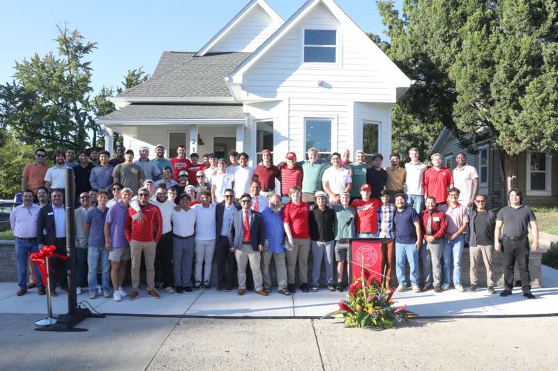 a group of people standing in front of a house