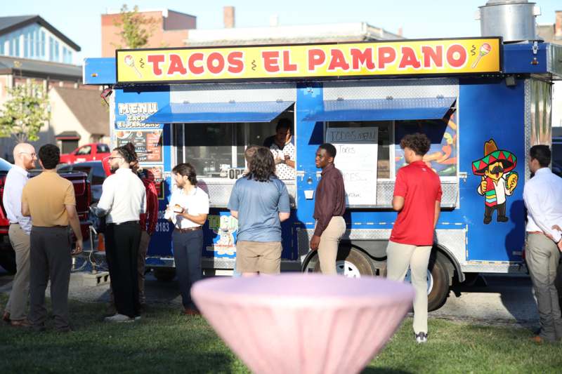 a group of people standing in front of a food truck