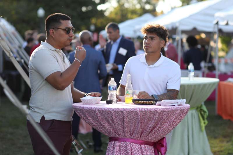 a man standing at a table with food and drinks