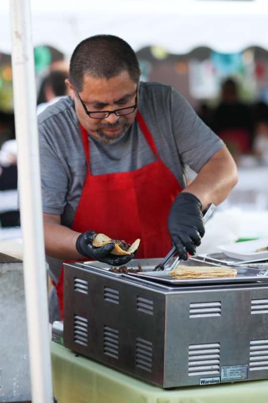 a man wearing an apron and gloves preparing food