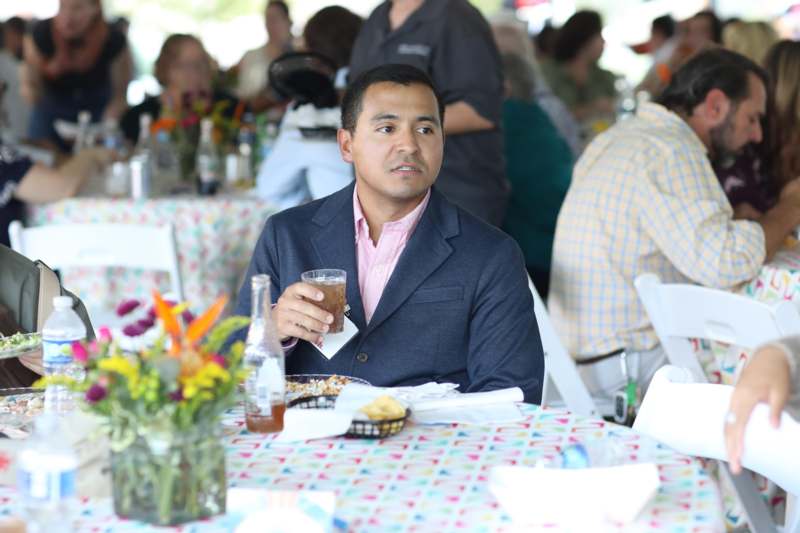 a man sitting at a table with food and drinks