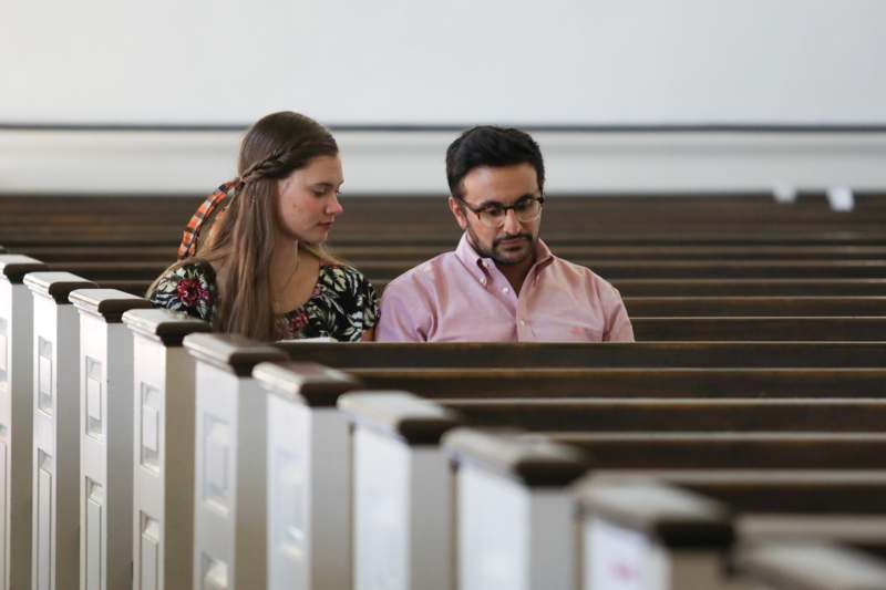 a man and woman sitting in pews