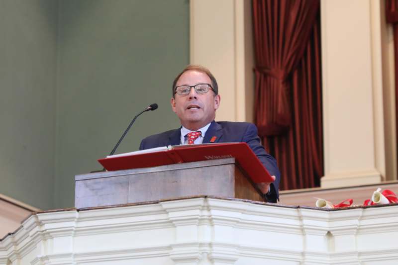 a man in a suit and tie at a podium
