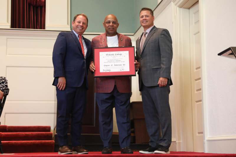 a group of men standing on stairs holding a certificate