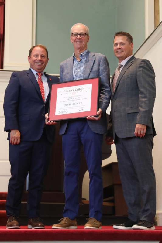a group of men standing on stairs holding a certificate