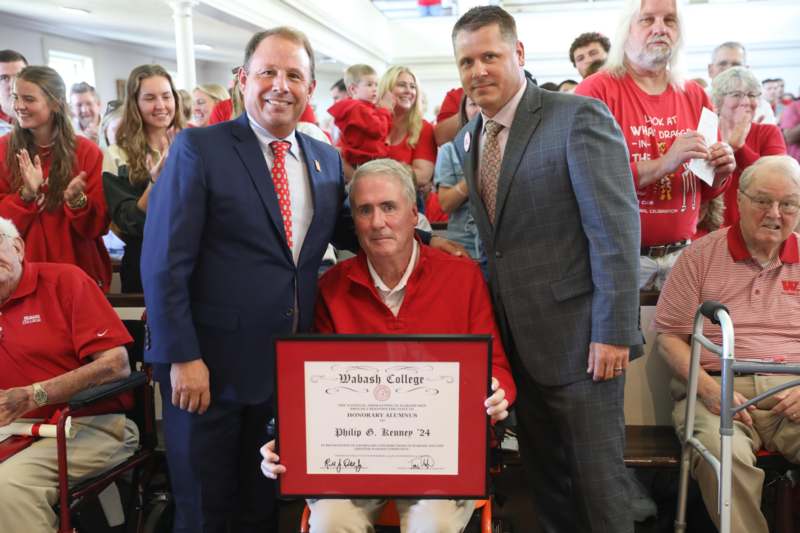a man in a wheelchair holding a certificate