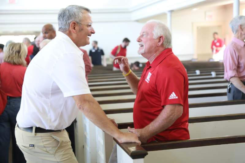 a man talking to another man in a church