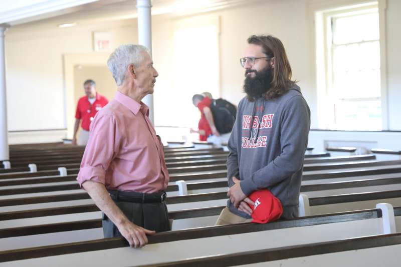 a man talking to another man in a church