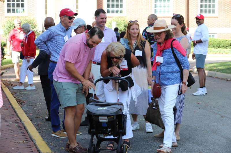 a group of people standing around a woman with a stroller