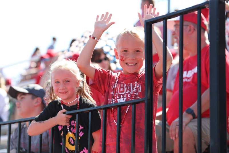 a boy and girl waving at a crowd