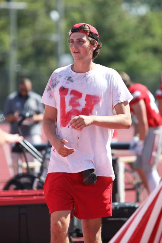 a man wearing a white shirt and red shorts