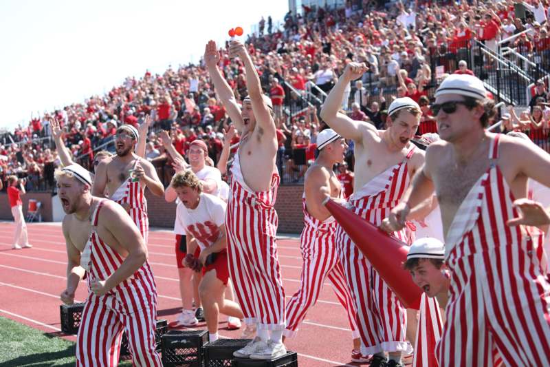 a group of people in striped overalls on a track