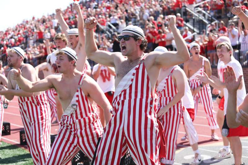 a group of men wearing red and white striped overalls