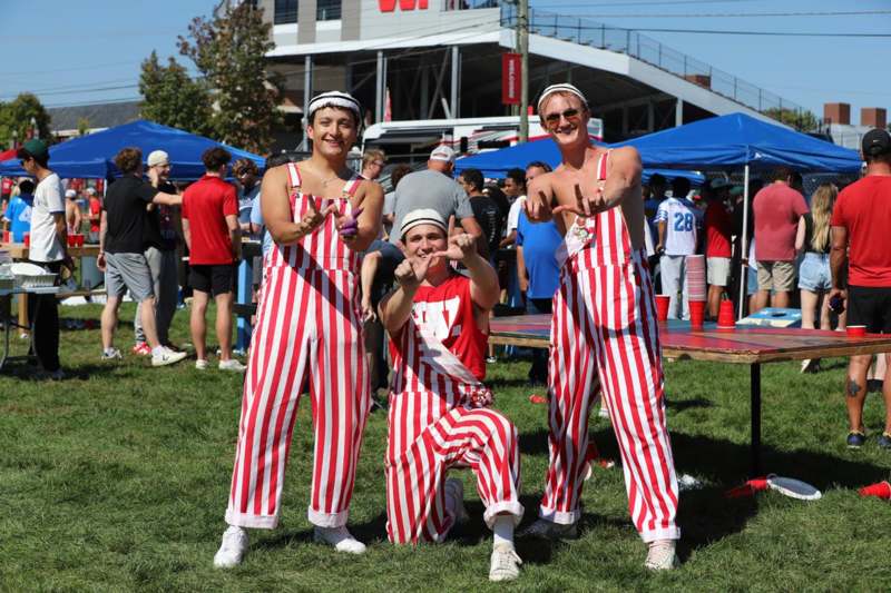 a group of men wearing striped overalls and posing for a picture