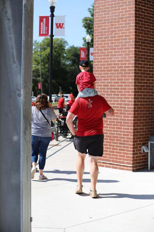 a man carrying a child on his shoulders