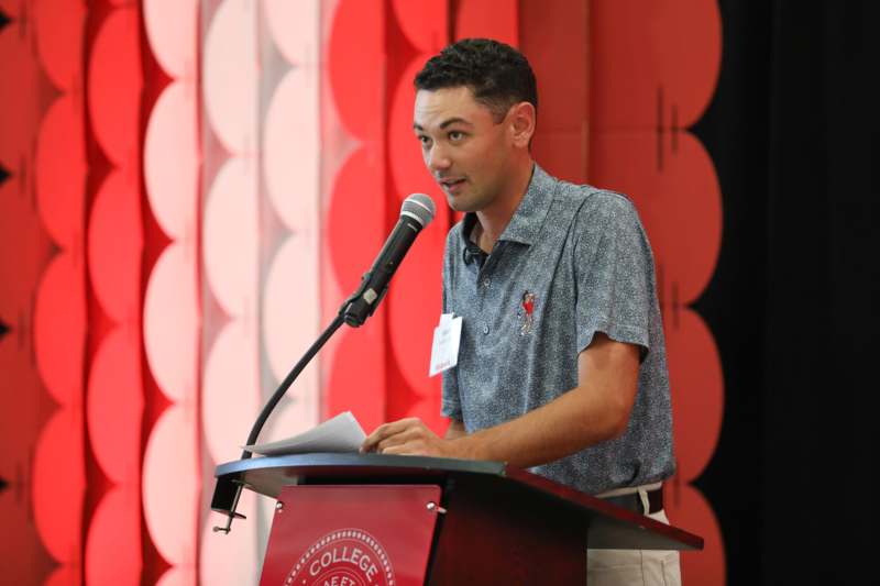 a man standing at a podium with a microphone