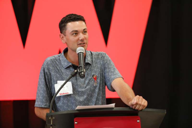 a man standing at a podium with a microphone