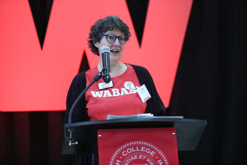 a woman standing at a podium with a microphone